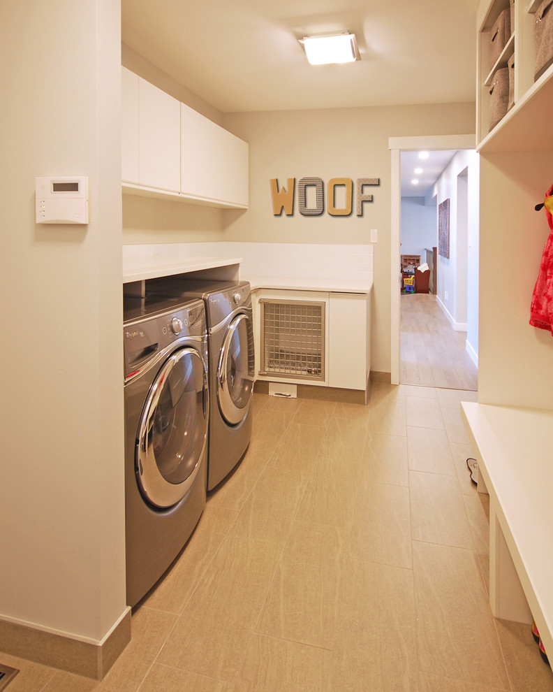This is an example of a mid-sized contemporary single-wall utility room in Edmonton with flat-panel cabinets, white cabinets, quartz benchtops, grey walls, porcelain floors and a side-by-side washer and dryer.
