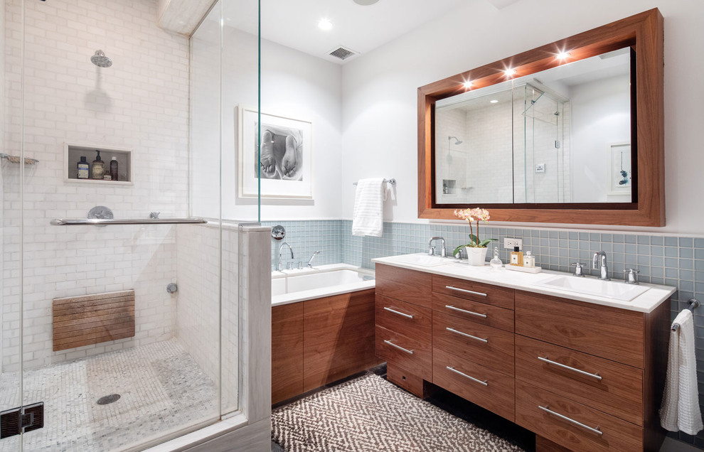 This is an example of a mid-sized contemporary master wet room bathroom in New York with flat-panel cabinets, medium wood cabinets, multi-coloured tile, ceramic tile, white walls, dark hardwood floors, an undermount sink, marble benchtops, a hinged shower door, white benchtops and a drop-in tub.
