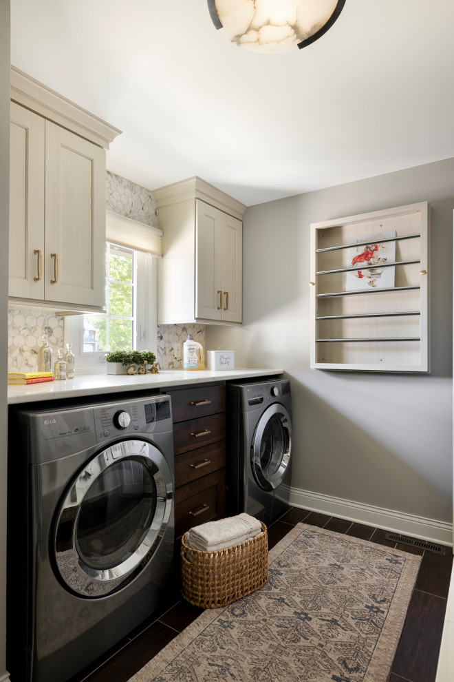 Inspiration for a mid-sized timeless galley ceramic tile and brown floor utility room remodel in Minneapolis with flat-panel cabinets, brown cabinets, quartz countertops, white backsplash, ceramic backsplash, gray walls, a side-by-side washer/dryer and white countertops
