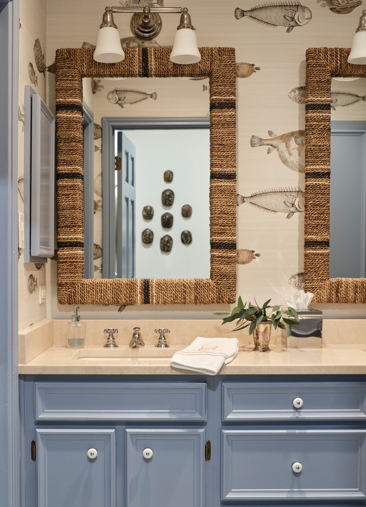 オースティンにあるトラディショナルスタイルのおしゃれな浴室 (家具調キャビネット、青いキャビネット、ベージュの壁、御影石の洗面台、ベージュのカウンター、洗面台2つ、造り付け洗面台、壁紙) の写真