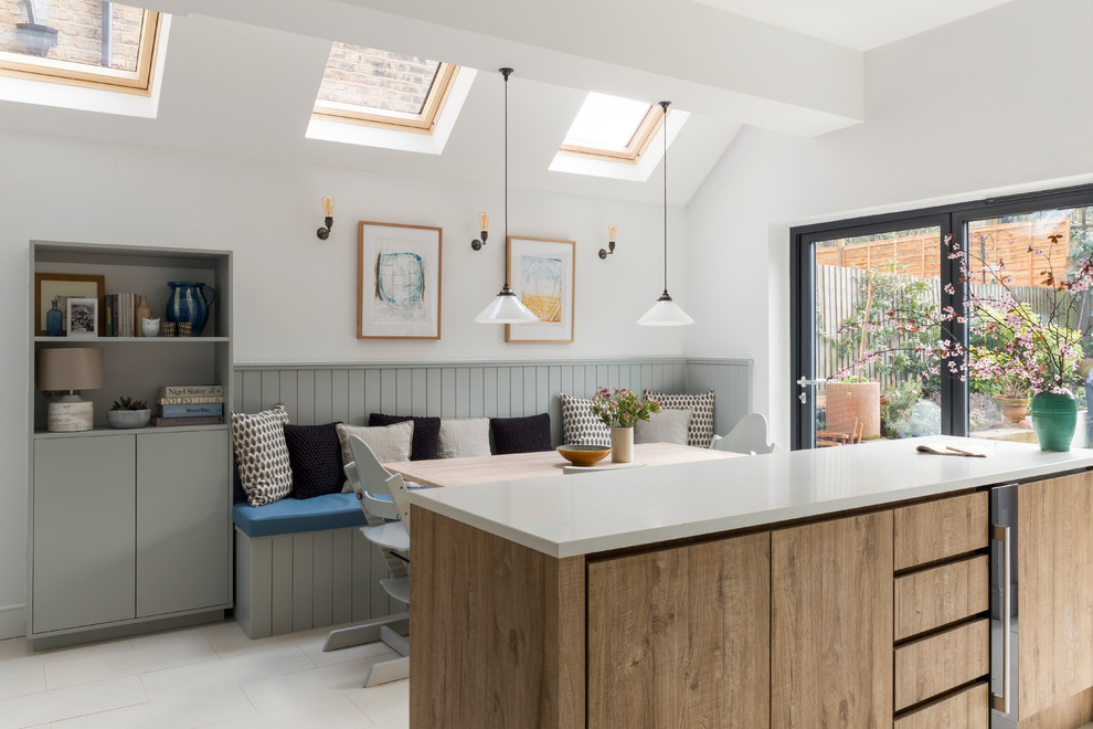 Inspiration for a transitional eat-in kitchen in London with flat-panel cabinets, light wood cabinets and with island.