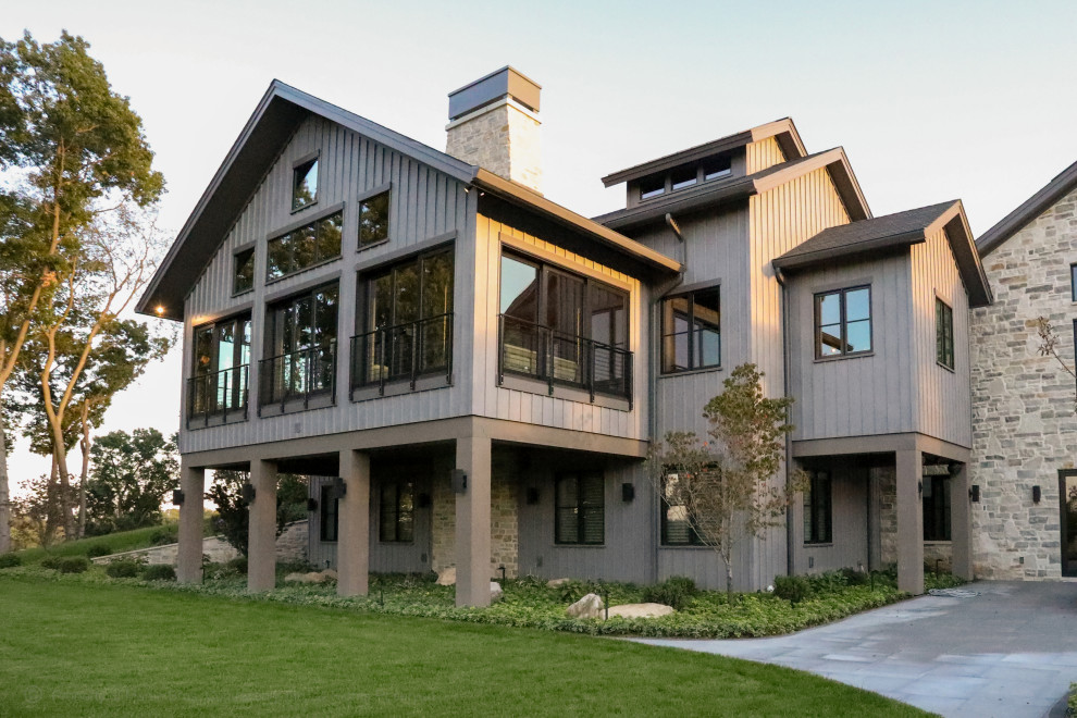 Huge craftsman two-story board and batten house exterior idea in Other with a mixed material roof