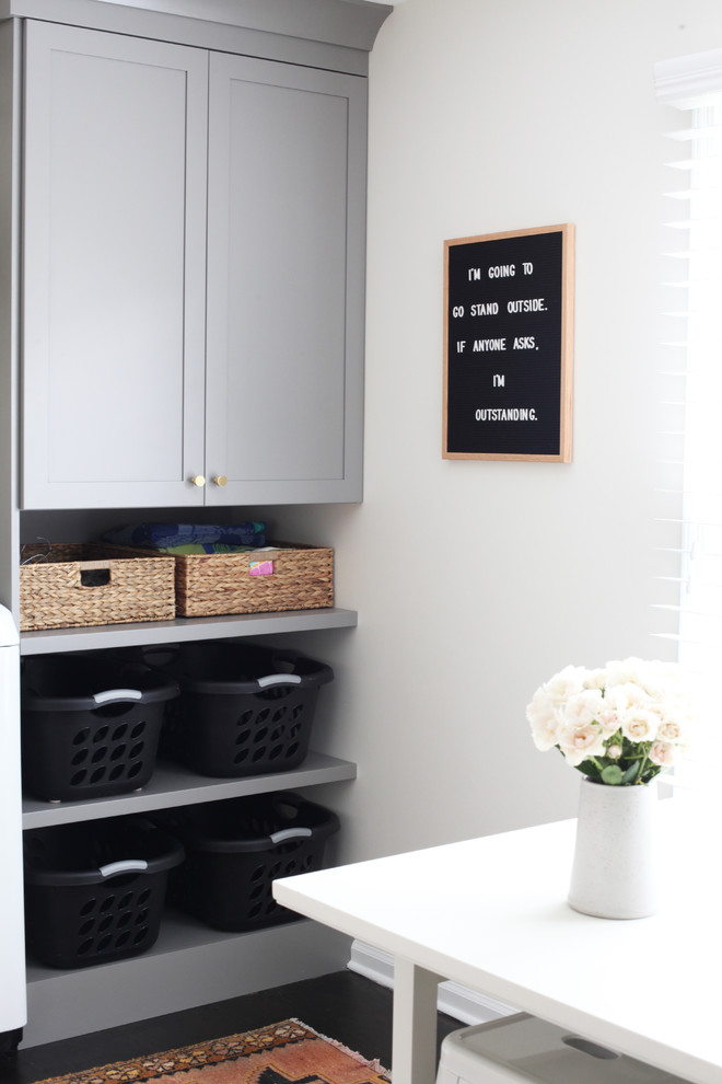 Example of a small transitional dark wood floor and brown floor laundry room design in Chicago with gray cabinets, wood countertops and a side-by-side washer/dryer