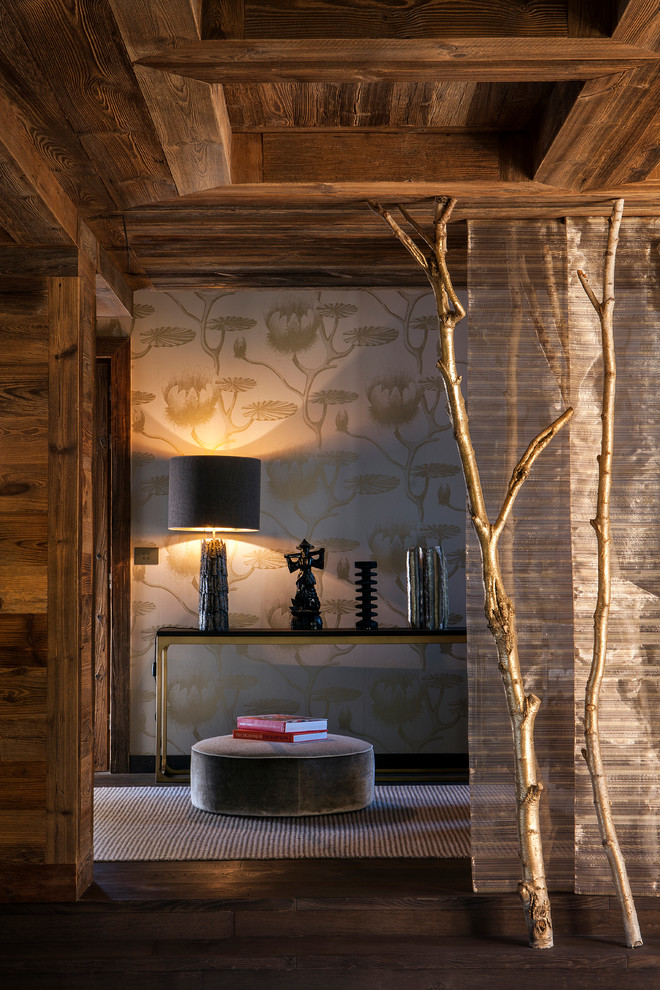 Cette image montre un couloir chalet de taille moyenne avec un mur marron et un sol en bois foncé.