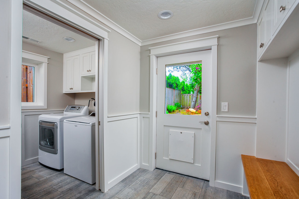 Design ideas for a mid-sized transitional utility room in Other with shaker cabinets, white cabinets, grey walls, porcelain floors, a side-by-side washer and dryer and grey floor.
