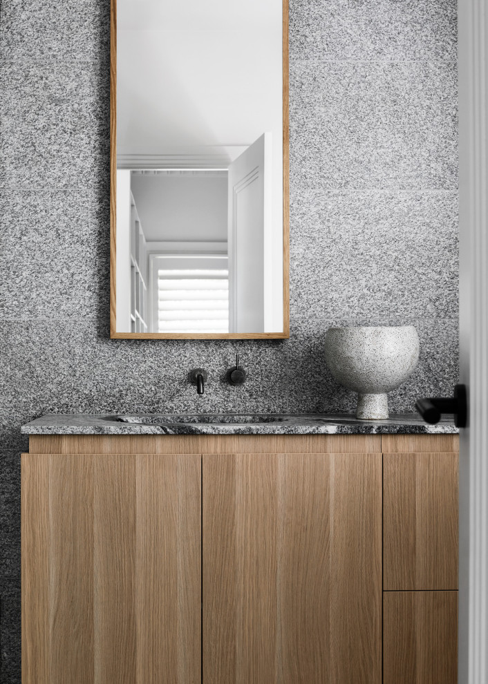 Design ideas for a medium sized modern family bathroom in Melbourne with recessed-panel cabinets, grey cabinets, a freestanding bath, white tiles, porcelain tiles, white walls, porcelain flooring, a submerged sink, granite worktops, grey floors, grey worktops, a single sink and a built in vanity unit.
