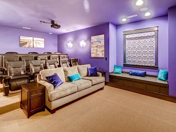 Photo of a mid-sized traditional enclosed home theatre in Other with purple walls, carpet and a projector screen.