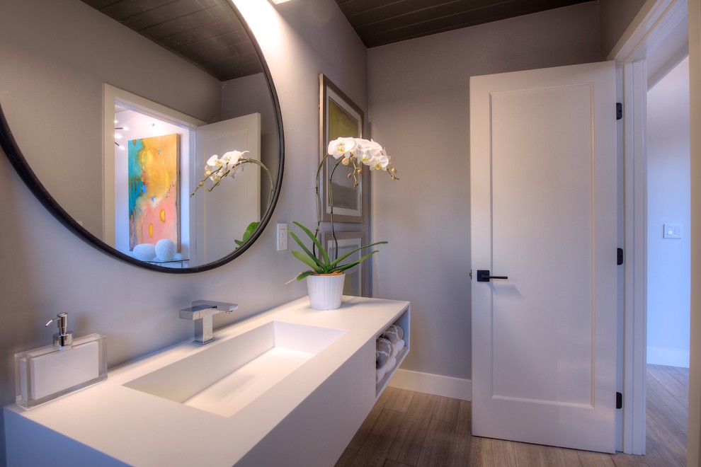 Mid-sized midcentury bathroom in San Francisco with a trough sink, open cabinets, white cabinets, engineered quartz benchtops, white walls and light hardwood floors.