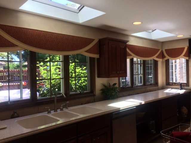 Example of a mid-sized transitional single-wall kitchen design in Chicago with an integrated sink, raised-panel cabinets, dark wood cabinets, laminate countertops and stainless steel appliances