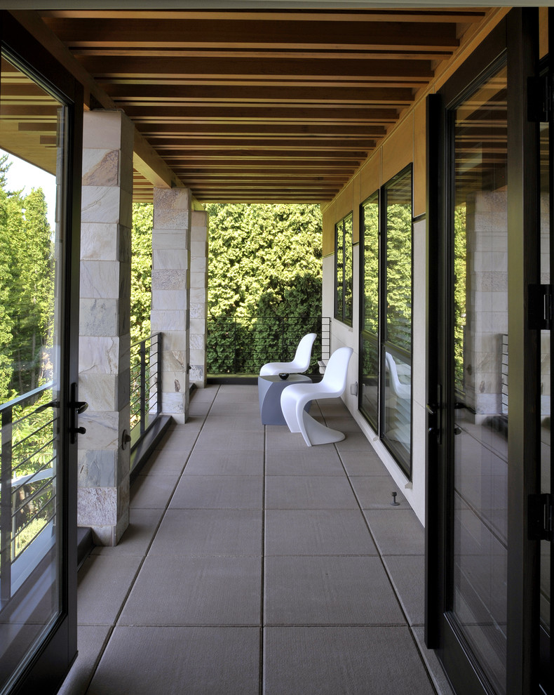 Photo of a contemporary balcony in Seattle with a roof extension.