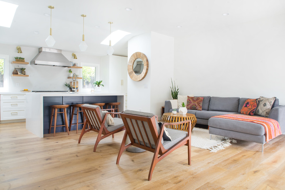 Design ideas for a mid-sized midcentury open concept living room in Orange County with white walls and light hardwood floors.