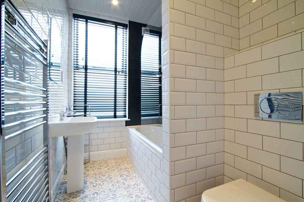 Photo of a mid-sized contemporary master bathroom in London with an alcove tub, a wall-mount toilet and white walls.