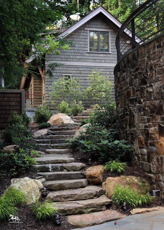 This is an example of a mid-sized traditional sloped partial sun garden in Other with a retaining wall and natural stone pavers.