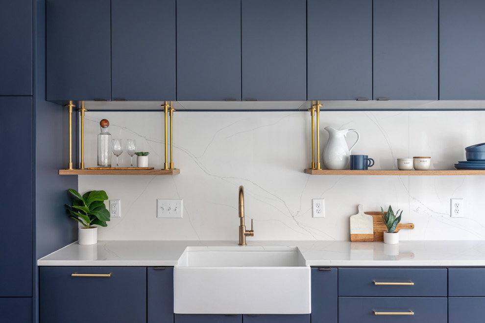 Design ideas for a mid-sized contemporary l-shaped eat-in kitchen in Raleigh with a farmhouse sink, flat-panel cabinets, blue cabinets, quartzite benchtops, white splashback, engineered quartz splashback, panelled appliances, medium hardwood floors, with island, brown floor and white benchtop.