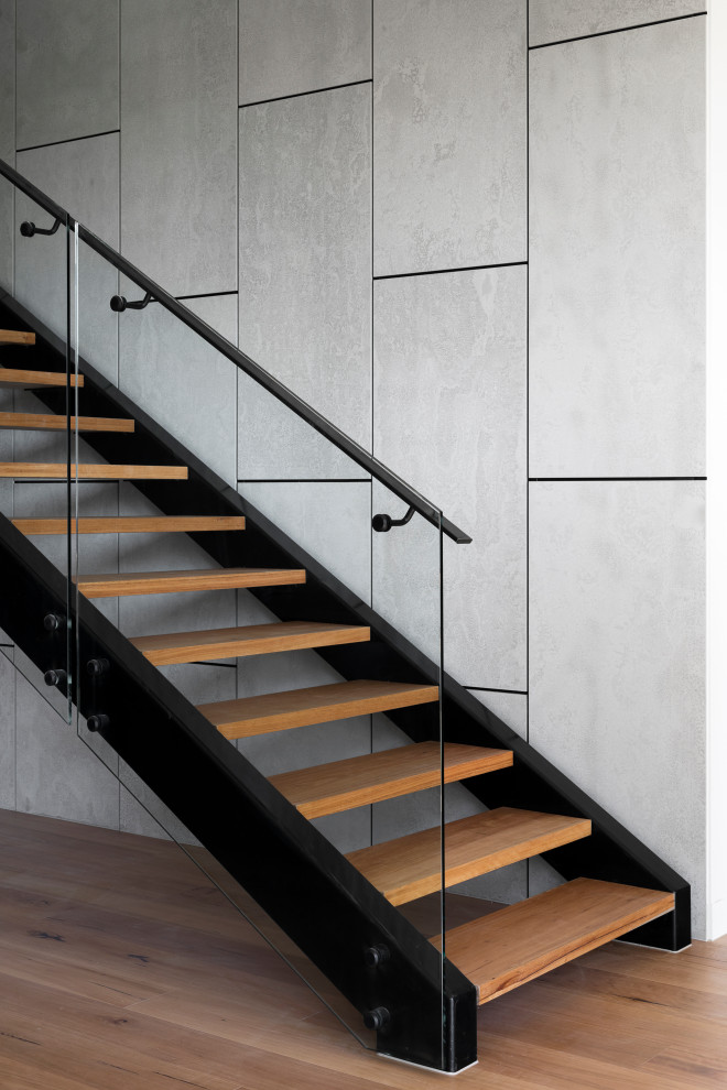 Photo of a mid-sized contemporary wood straight staircase in Melbourne with metal railing and panelled walls.