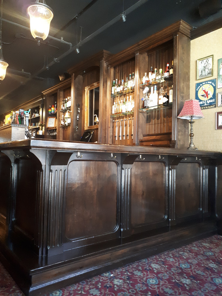 This is an example of a large traditional home bar in Toronto.