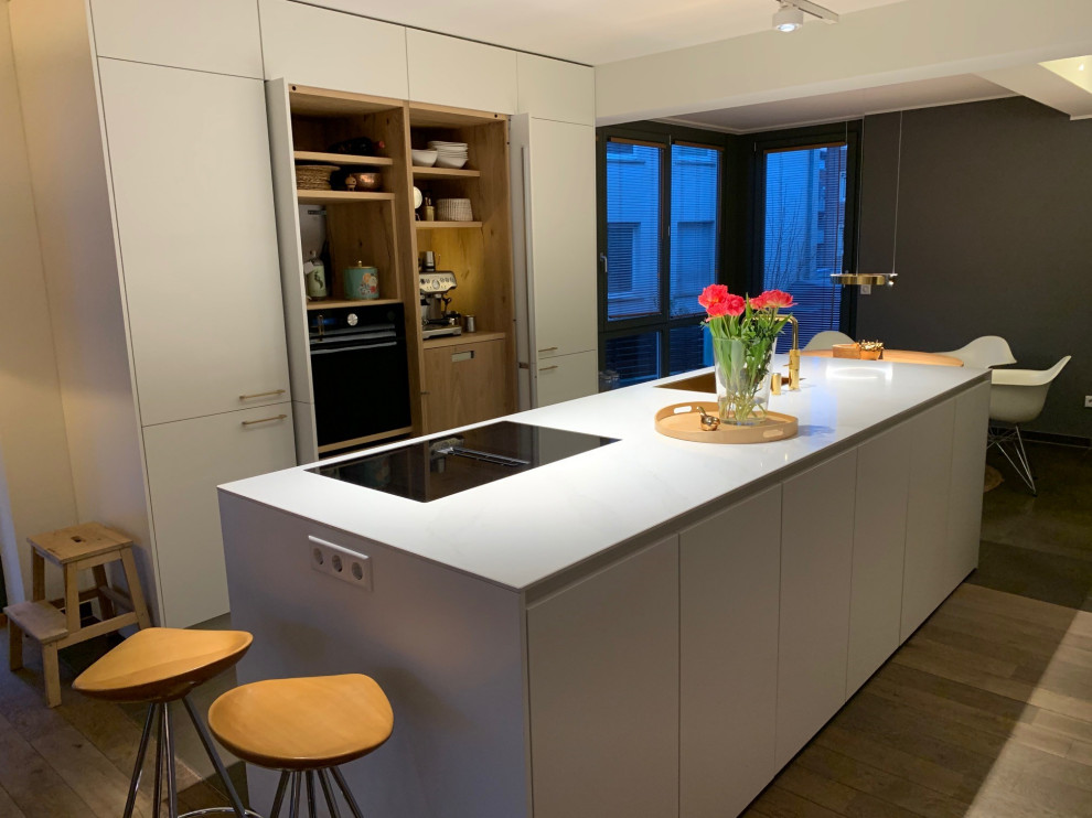Ispirazione per una grande cucina moderna con top in quarzo composito e pavimento in legno massello medio