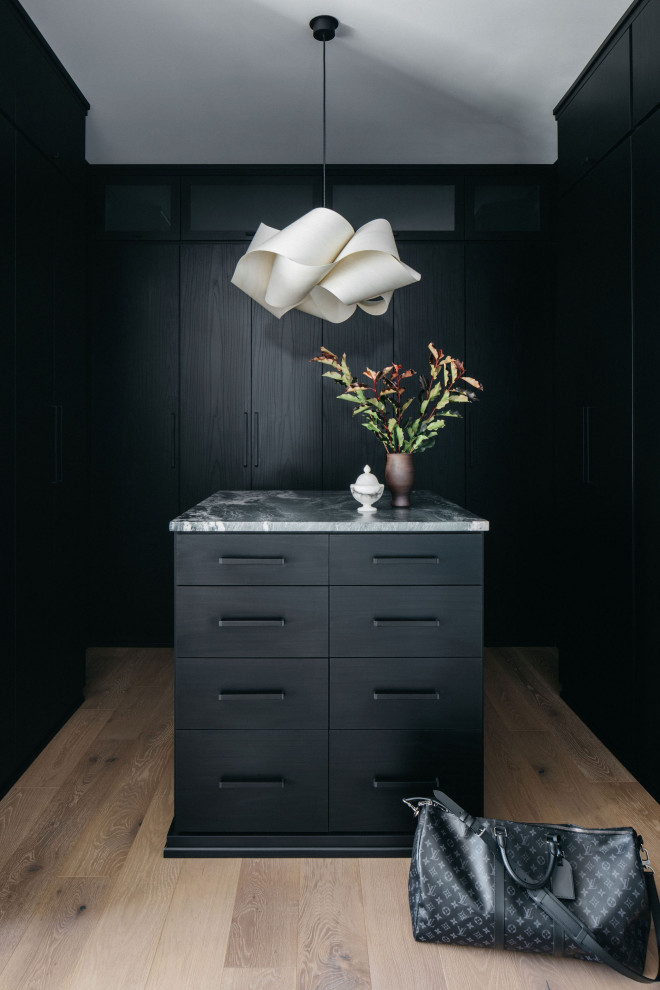 Ispirazione per una cabina armadio contemporanea con ante lisce, ante nere e pavimento grigio