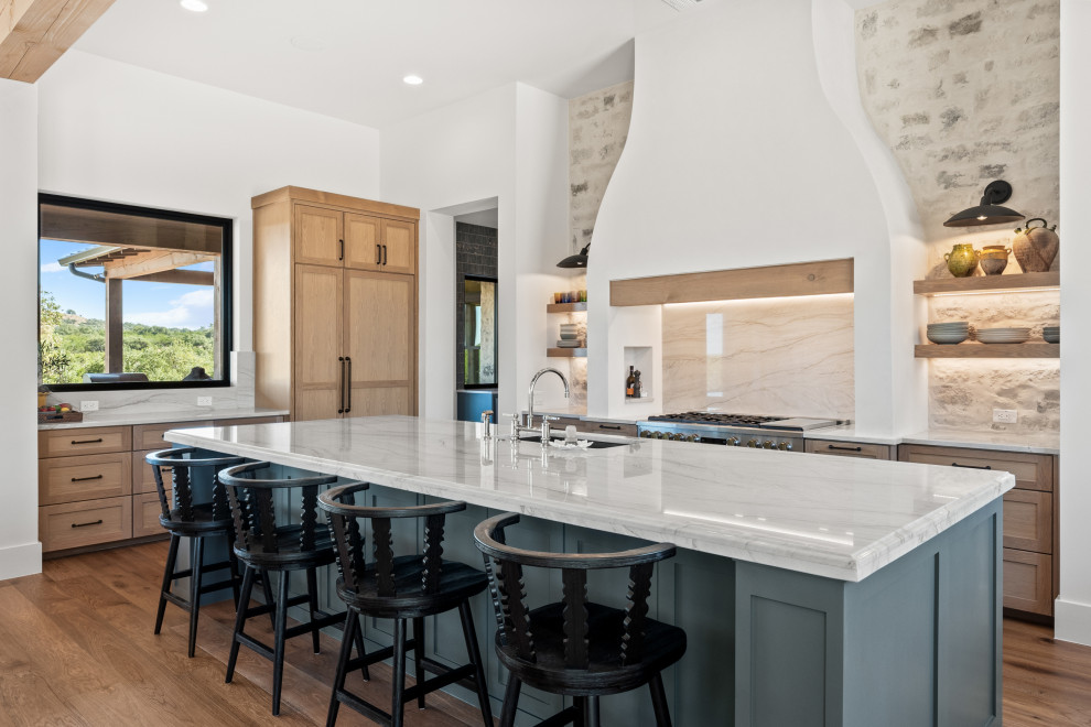 Inspiration for a huge transitional medium tone wood floor and brown floor kitchen remodel in Austin with shaker cabinets, quartzite countertops, white backsplash, stone slab backsplash, paneled appliances and an island