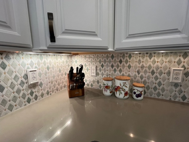 Inspiration for a large transitional u-shaped eat-in kitchen remodel with raised-panel cabinets, white cabinets, quartz countertops, green backsplash, mosaic tile backsplash, an island and green countertops