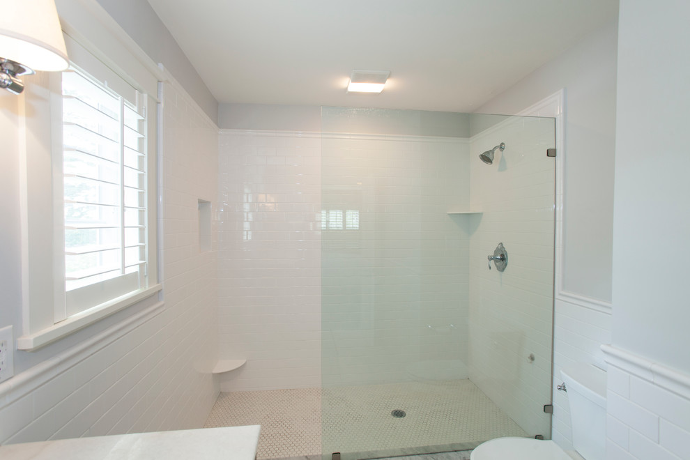 Photo of a mid-sized traditional master bathroom in Philadelphia with an undermount sink, flat-panel cabinets, dark wood cabinets, white tile, subway tile, grey walls and marble floors.