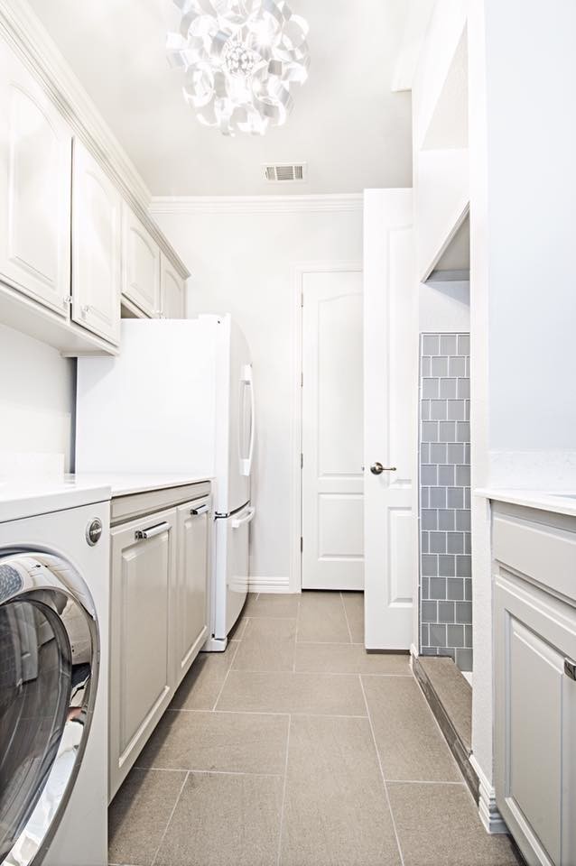 Photo of a small transitional galley laundry room in Dallas with an undermount sink, raised-panel cabinets, grey cabinets, quartz benchtops, grey walls, porcelain floors and a side-by-side washer and dryer.