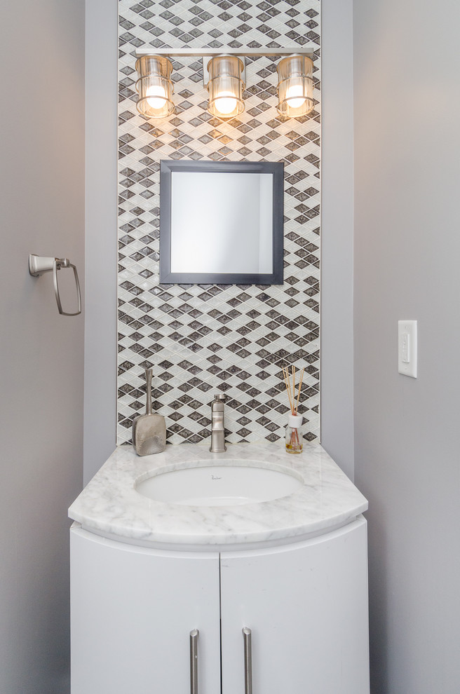 Inspiration for a mid-sized contemporary powder room in Baltimore with flat-panel cabinets, white cabinets, brown tile, white tile, mosaic tile, grey walls, an undermount sink, marble benchtops and white benchtops.