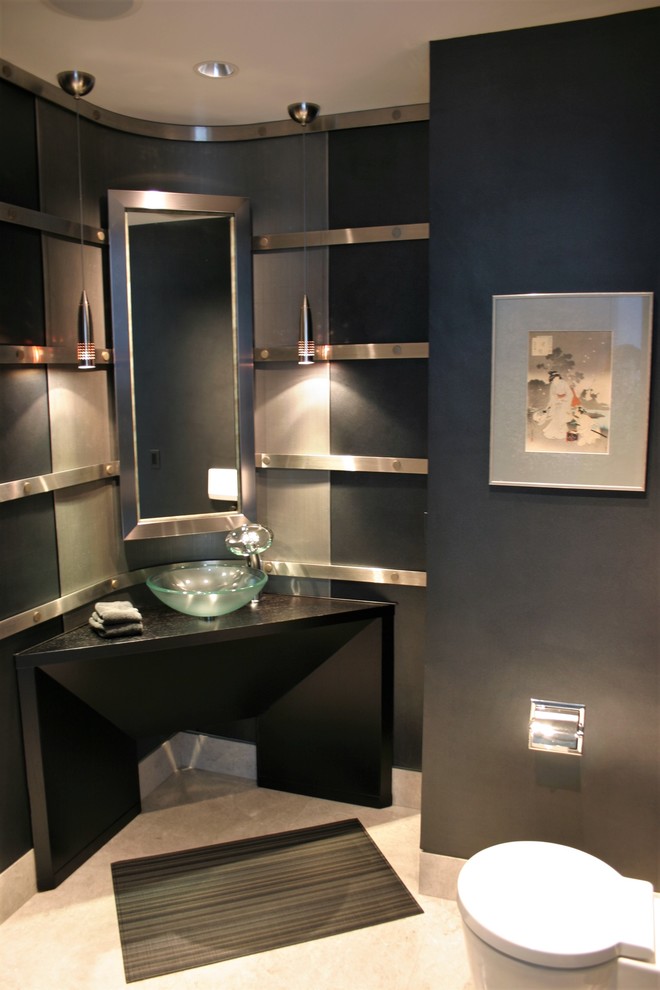 This is an example of a mid-sized modern powder room in Austin with black walls, limestone floors, a vessel sink, black cabinets, a two-piece toilet, engineered quartz benchtops, beige floor and black benchtops.