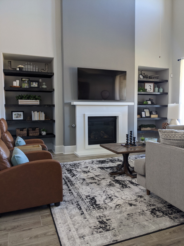 Großes, Offenes Landhaus Wohnzimmer mit weißer Wandfarbe, Keramikboden, Kamin, verputzter Kaminumrandung, TV-Wand, grauem Boden und gewölbter Decke in Austin