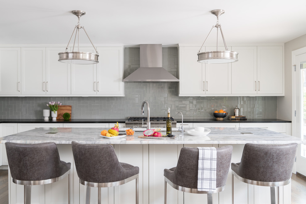 This is an example of a transitional kitchen in Other with shaker cabinets, white cabinets, grey splashback, stainless steel appliances, with island and black benchtop.