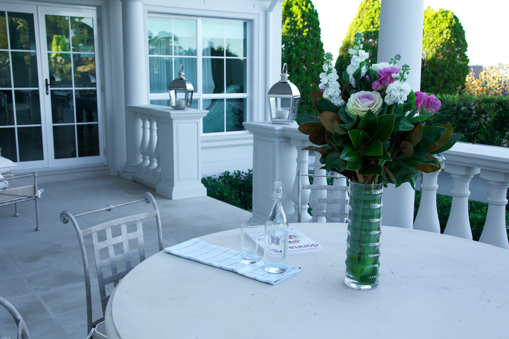 Inspiration for a mid-sized contemporary courtyard patio in Sydney with natural stone pavers and an awning.