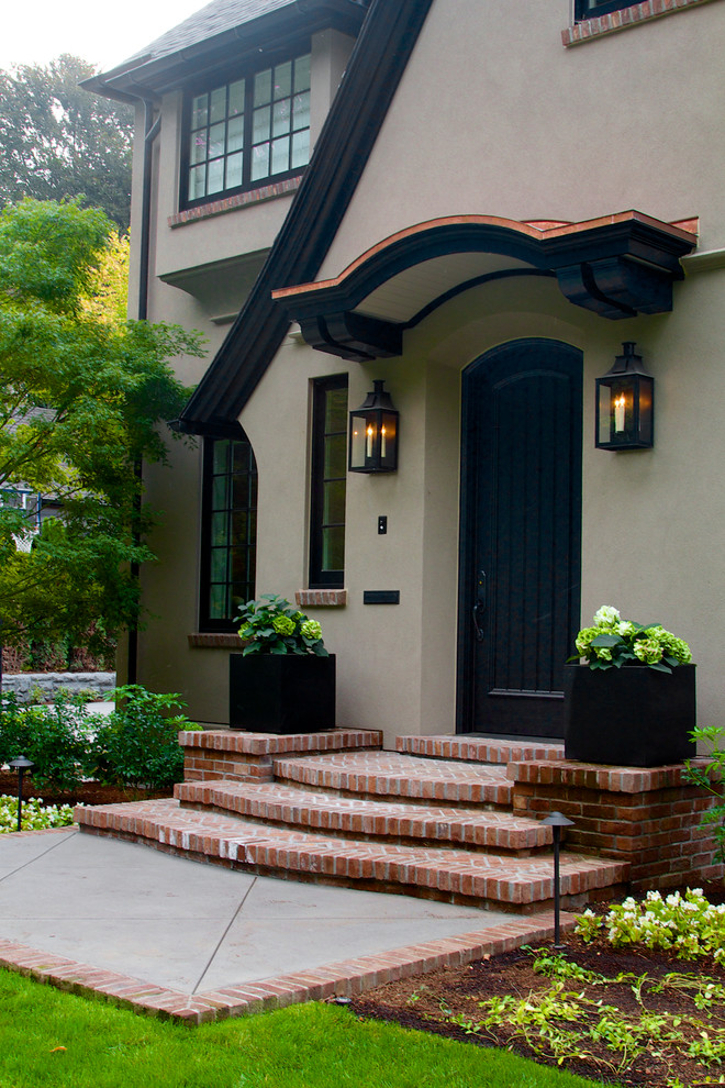 Example of a large classic beige two-story stucco gable roof design in Portland