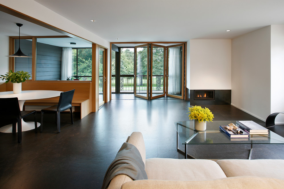 Large midcentury open concept living room in Seattle with white walls, a ribbon fireplace, a metal fireplace surround, no tv and cork floors.