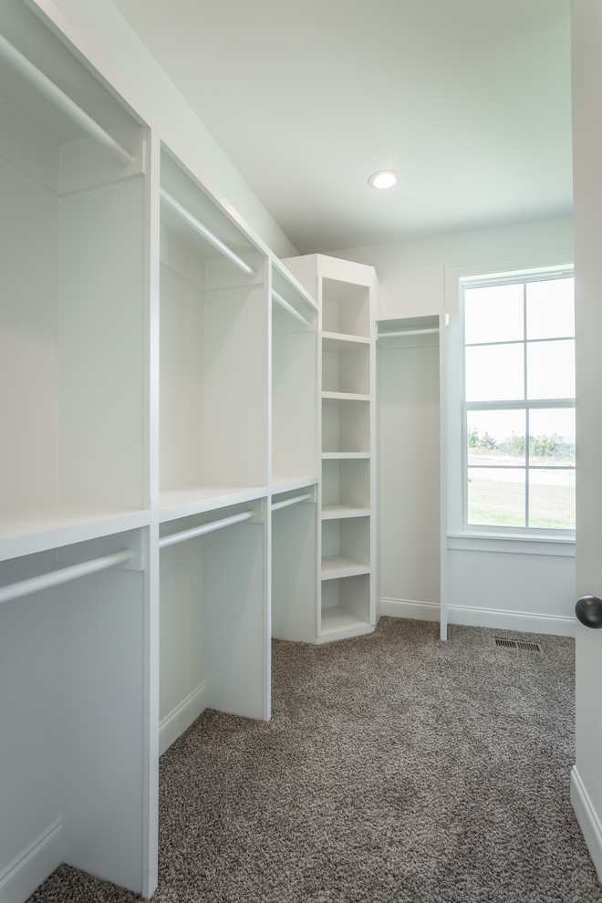 Design ideas for a mid-sized arts and crafts gender-neutral walk-in wardrobe in Other with carpet and grey floor.