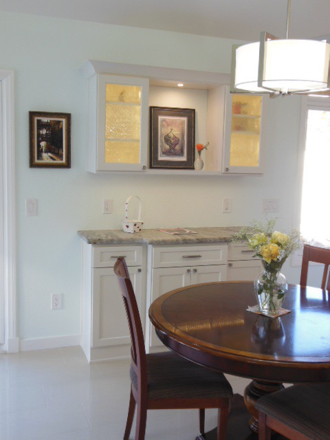 Inspiration for a mid-sized transitional l-shaped porcelain tile and white floor eat-in kitchen remodel in San Diego with shaker cabinets, white cabinets, quartz countertops, stainless steel appliances and an island