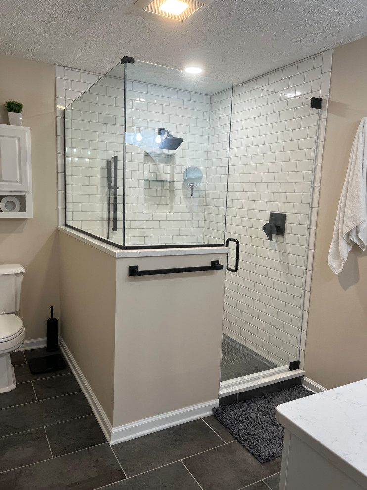 Mid-sized country master bathroom in Indianapolis with shaker cabinets, white cabinets, a corner shower, a two-piece toilet, white tile, subway tile, beige walls, porcelain floors, an undermount sink, quartzite benchtops, grey floor, a hinged shower door, white benchtops, a niche, a single vanity and a built-in vanity.