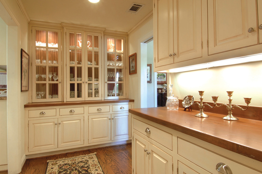 Inspiration for a large traditional single-wall open plan kitchen in Los Angeles with white cabinets, wood benchtops, white splashback, light hardwood floors, no island and raised-panel cabinets.