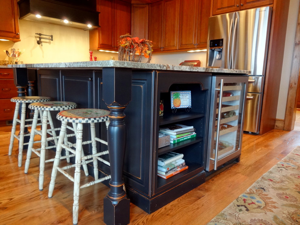 Inspiration for a large rustic u-shaped light wood floor eat-in kitchen remodel in Charlotte with a farmhouse sink, raised-panel cabinets, dark wood cabinets, granite countertops, beige backsplash, stainless steel appliances and an island