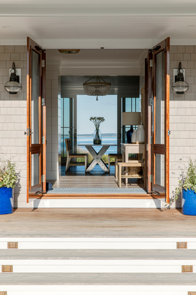 Esempio di una porta d'ingresso costiera di medie dimensioni con pareti bianche, pavimento in legno massello medio, una porta a due ante, una porta in legno bruno e pareti in perlinato