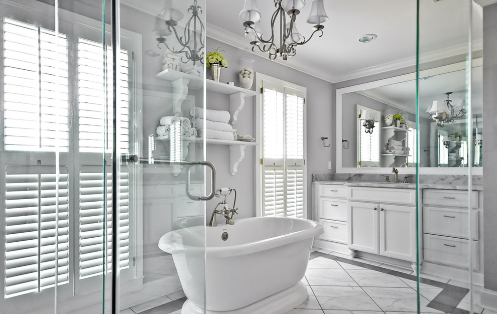 Inspiration for a large transitional master white tile white floor freestanding bathtub remodel with recessed-panel cabinets, white cabinets, white walls, an undermount sink and a hinged shower door
