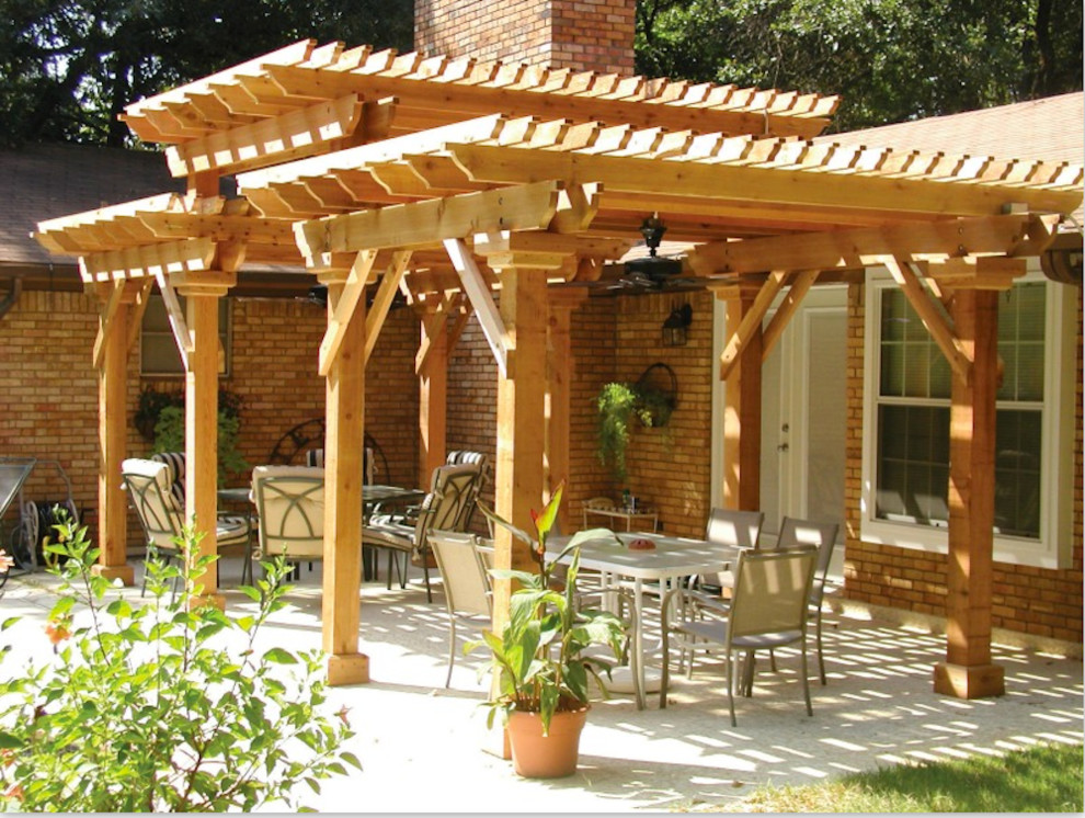 This is an example of a country backyard patio in Portland with brick pavers and a pergola.