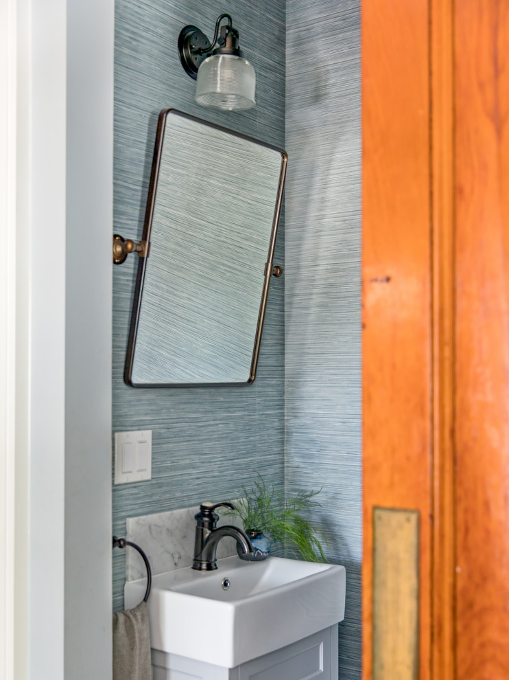 Immagine di un bagno di servizio classico con pareti blu e carta da parati
