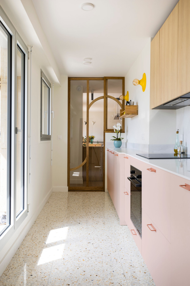 Mid-sized contemporary single-wall separate kitchen in Paris with pink cabinets, quartzite benchtops, white splashback, engineered quartz splashback, black appliances, terrazzo floors, multi-coloured floor and white benchtop.