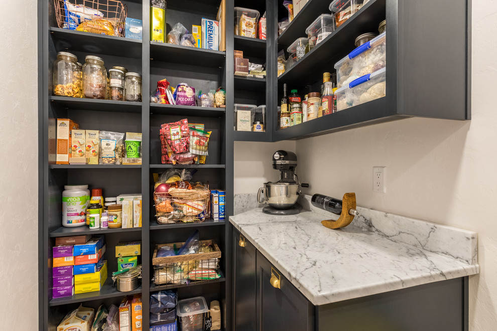 This is an example of a mid-sized modern kitchen pantry in Portland with shaker cabinets, black cabinets, marble benchtops, white splashback, marble splashback, light hardwood floors and white benchtop.