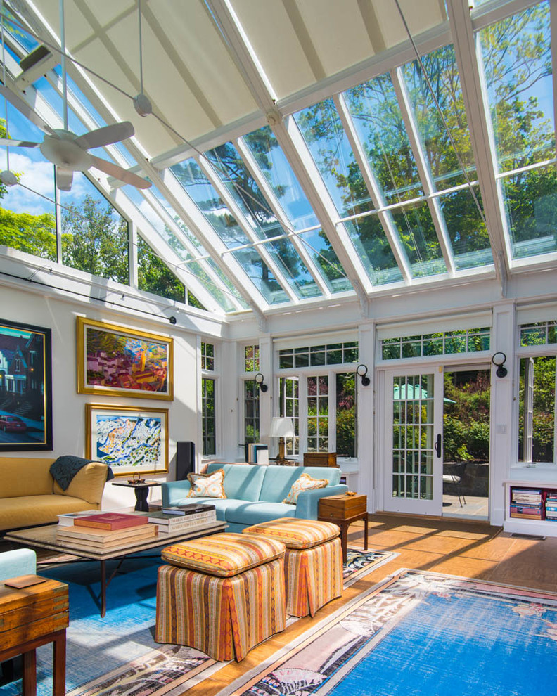Design ideas for a transitional sunroom in New York with medium hardwood floors, a glass ceiling and yellow floor.