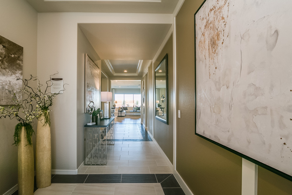 This is an example of a mid-sized contemporary entry hall in Phoenix with beige walls, ceramic floors, a single front door, a glass front door and beige floor.