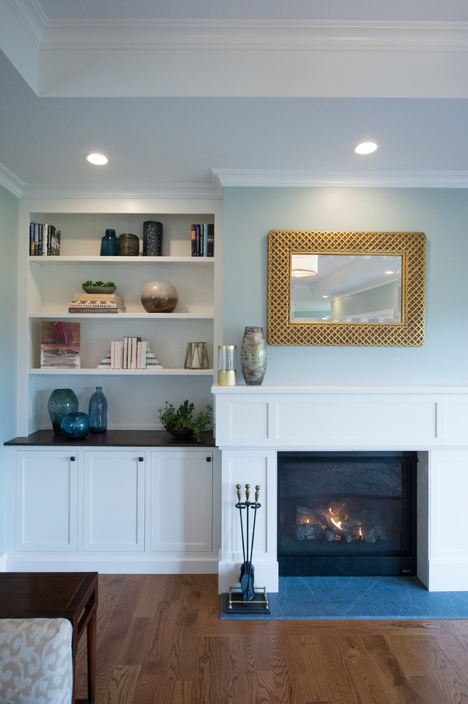 Inspiration for an expansive transitional family room in Boston with blue walls, medium hardwood floors, a standard fireplace, a tile fireplace surround, a built-in media wall and brown floor.