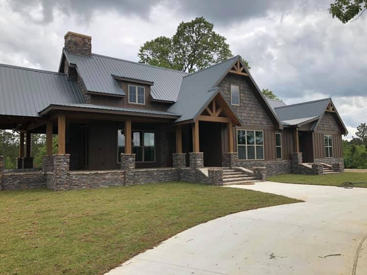 Large mountain style brown two-story wood gable roof photo with a metal roof