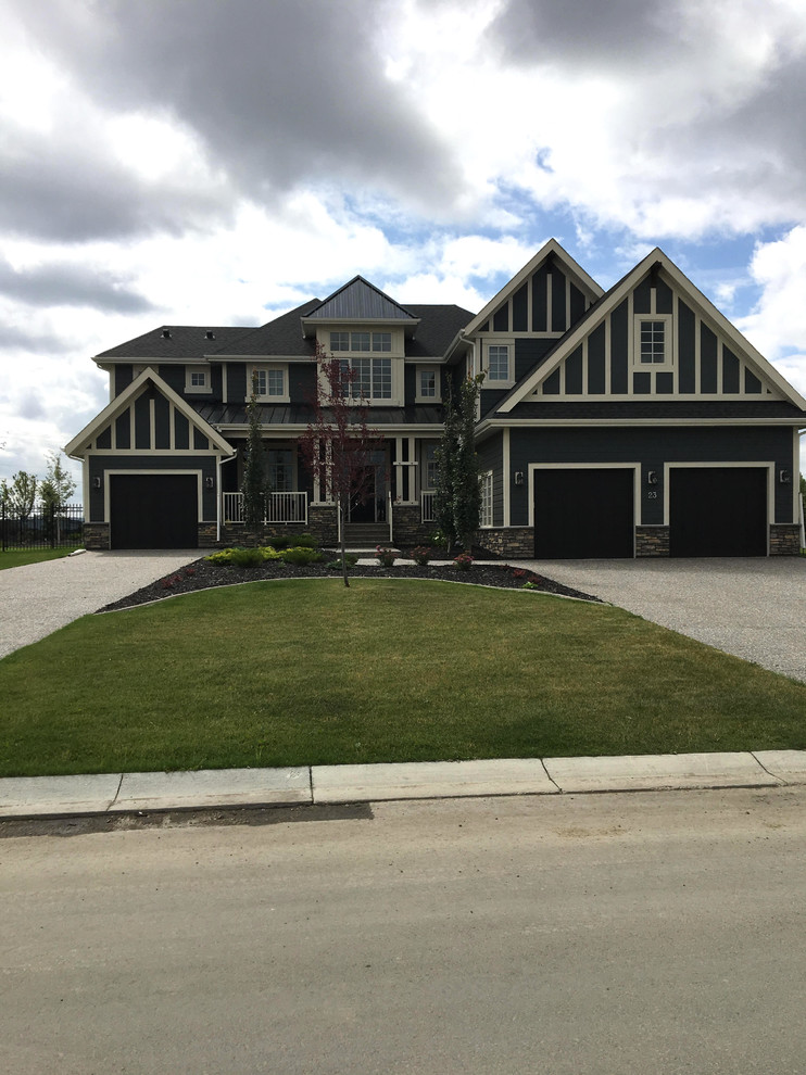 This is an example of a large traditional two-storey stucco beige house exterior in Calgary with a hip roof and a shingle roof.