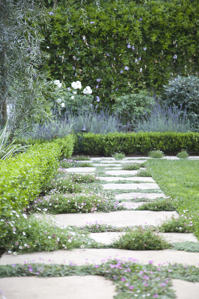Inspiration for a mid-sized traditional backyard formal garden in Los Angeles with a fire feature.
